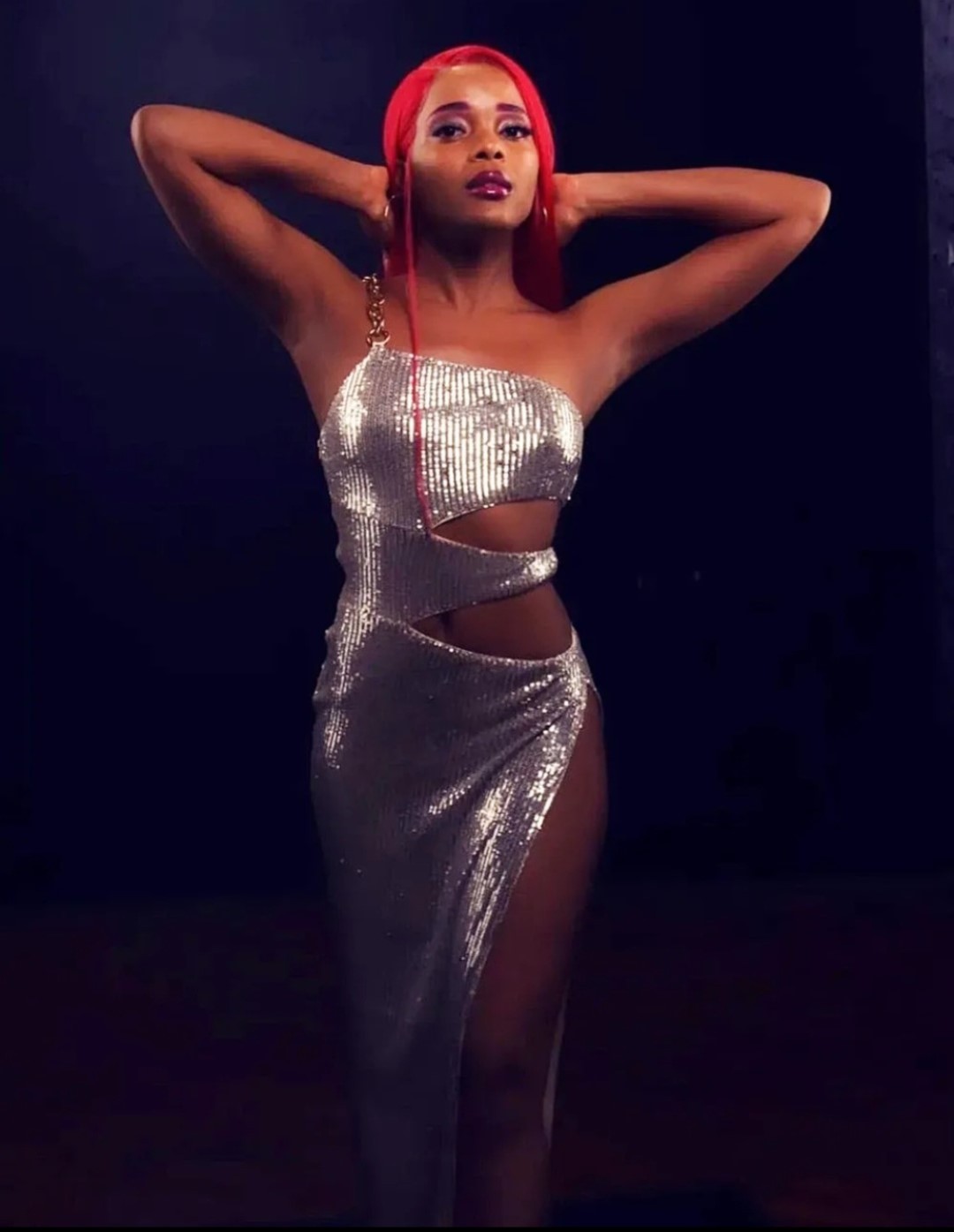 AlxZandria in a silver sequin gown on a dark stage